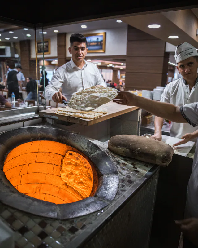 Flatbreads being taken from an oven at Bayramoğlu Döner